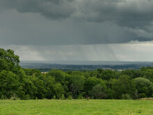Rain Falling In The Distance On A View Of The Cotswolds Region Of The English Countryside In Summer
