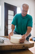 © Davide Illini/Stocksy - Senior man making homemade cheese