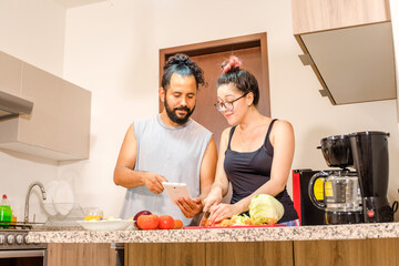 Pareja de mexicanos preparando ensalda en casa vida saludable