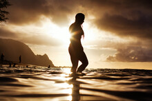 A Silhouette Of A Pretty Girl Walking In The Hawaiian Ocean With A Golden Magical Sun Setting