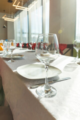 Wall Mural - Empty glasses set in restaurant.Served for a banquet table.detail of a dining table set up with wine glasses.Served holiday table, cutlery, crockery, glasses, plate, forks on white table.catering