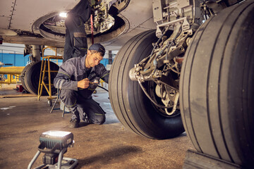 Landing gear airplane in hangar chassis rubber with aviation worker in uniform