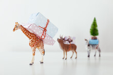 Toy Animals Carrying Christmas Gifts On White.