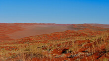 Panoramic View Over A Valley Surrounded By Big Red Colored Sand Dunes Covered By Dried Our Yellow Grass Near Sesriem, Namib Desert, Namibia, Africa.