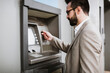 © Mauro Grigollo Photographer/Stocksy - Businessman using an ATM