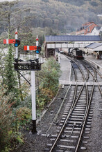 A Traditional British Train Signal Next To A Railway Station In Wales