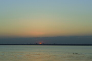 Wall Mural - Evening sun over the water surface