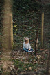 © Akela - from alp to alp/Stocksy - adorable little girl sitting thoughtful in a forest - black and white