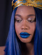 Extreme close-up of beautiful young African model with with electtric blue hair and blue lips