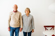 © BONNINSTUDIO/Stocksy - Portrait of an elderly couple standing on white.