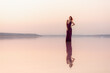 © Oleksandr - A beautiful young woman posing at sunset in the water with a reflection