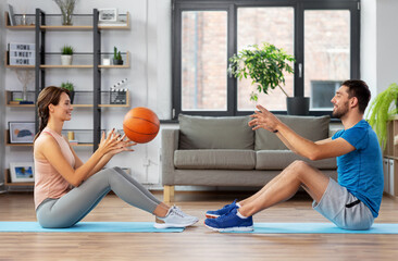 Wall Mural - fitness, sport and healthy lifestyle concept - happy couple exercising with ball at home