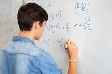 Wall Mural - College student solving math equation on white board