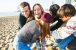 © BONNINSTUDIO/Stocksy - Group of teenage friends playing football on the beach.