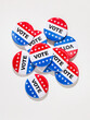 © Sean Locke Photography/Stocksy - Vote: Pile Of Voting Pins On White Textured Background