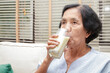 © SUPERMAO - Elderly Asian women drink milk containing calcium to prevent osteoporosis. Make the body strong and healthy