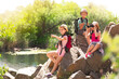© New Africa - School holidays. Group of happy children sitting on rocks near river