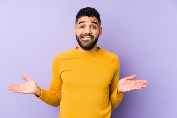 Young mixed race arabic man isolated confused and doubtful shrugging shoulders to hold a copy space.