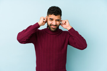 Wall Mural - Young mixed race arabic man isolated covering ears with hands.