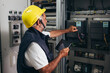 © cherryandbees - engineer checking the electrical cabinet at control room