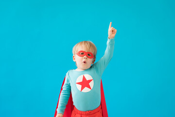 Portrait of superhero child against blue background