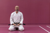 Karate master with black belt rank, in meditation position in his dojo or martial arts school