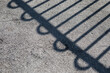 Metal Loop and Bar Fence shadow on concrete
