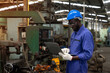 © godji10 - African american technician engineer use laptop to checking and control machines in the workplace on a business day. Industry worker working in the factory. Concept of Industrial manufacturing.