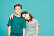 © Guille Faingold/Stocksy - Embracing boy and girl on blue background