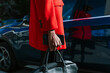© MyMicrostock/Stocksy - Stylish black woman with smartphone and bag opening car door in street