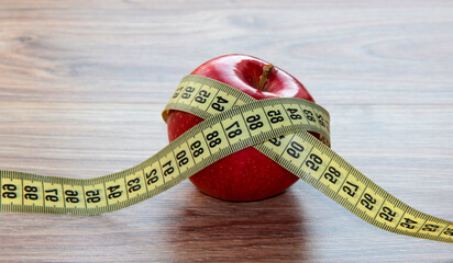 A red Apple is measured by a meter. Slimness and diet.