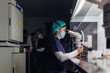© MyMicrostock/Stocksy - Biologists working on microscope in IVF laboratory