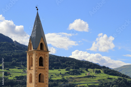 Fotomural VECCHIO CAMPANILE CON MONTAGNE A BORMIO ITALIA, OLD BELL TOWER WITH MOUNTAINS IN