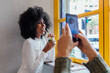 © MyMicrostock/Stocksy - Woman taking picture of female friend drinking juice