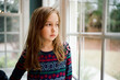 © Jakob Lagerstedt/Stocksy - Cute young girl looking out a window