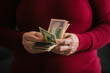 © Pixel Stories/Stocksy - Female hands holding money