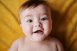 © Guille Faingold/Stocksy - Cute baby lying on blanket and smiling at camera