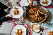 © Sergio Marcos/Stocksy - Family dinner with seafood paella and wine