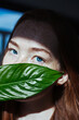 © vradiy.ru/Stocksy - Closeup portrait of young redhead woman with green leaf