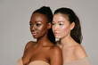 © Julie Meme/Stocksy - Closeup of Asian and black girls on the neutral background looking aside
