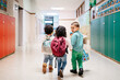 © Sergio Marcos/Stocksy - Happy kids walking in school corridor