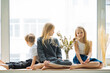 © Ivan Ozerov/Stocksy - three children are sitting on the windowsill