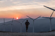 © Hakan & Sophie/Stocksy - man running towards wind generators