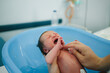 © JImena Roquero/Stocksy - Baby takes her first bath in the hospital