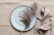 © Maria Altynbaeva/Stocksy - Ceramic plate with dried grass