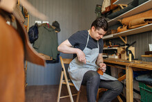 The Master Works In His Leather Workshop