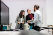 © Alvaro Sanchez/ADDICTIVE STOCK - Group of positive young colleagues in formal clothes gathering in contemporary coworking office with tablet having break during work