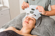 © Galdric Penarroja/ADDICTIVE STOCK - Crop unrecognizable beautician removing moisturizing cloth mask from face of relaxed female client during professional treatment in modern clinic