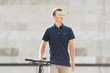 © Egoitz Bengoetxea/ADDICTIVE STOCK - Serious casual dressed young man in sunglasses walking with his urban bicycle and looking away