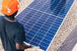 © Harry Rendon/ADDICTIVE STOCK - Back view of unrecognizable African American worker walking with solar panel on sunny day in industrial area